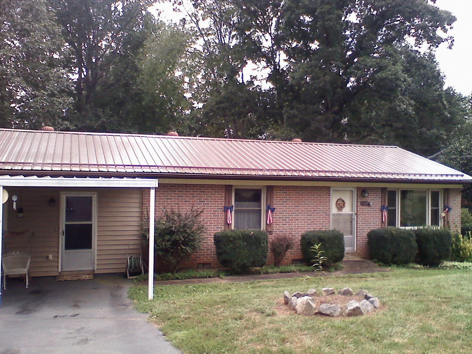 Bronze metal roof and carport on a brick ranch home — Roof Repair work by our crew in Holiday